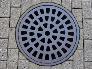 a manhole cover on a brick sidewalk