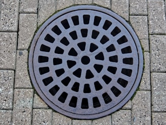 a manhole cover on a brick sidewalk
