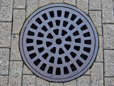 a manhole cover on a brick sidewalk