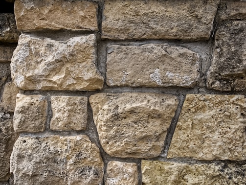 Close-up of a rustic stone wall with varied textures and earthy tones.