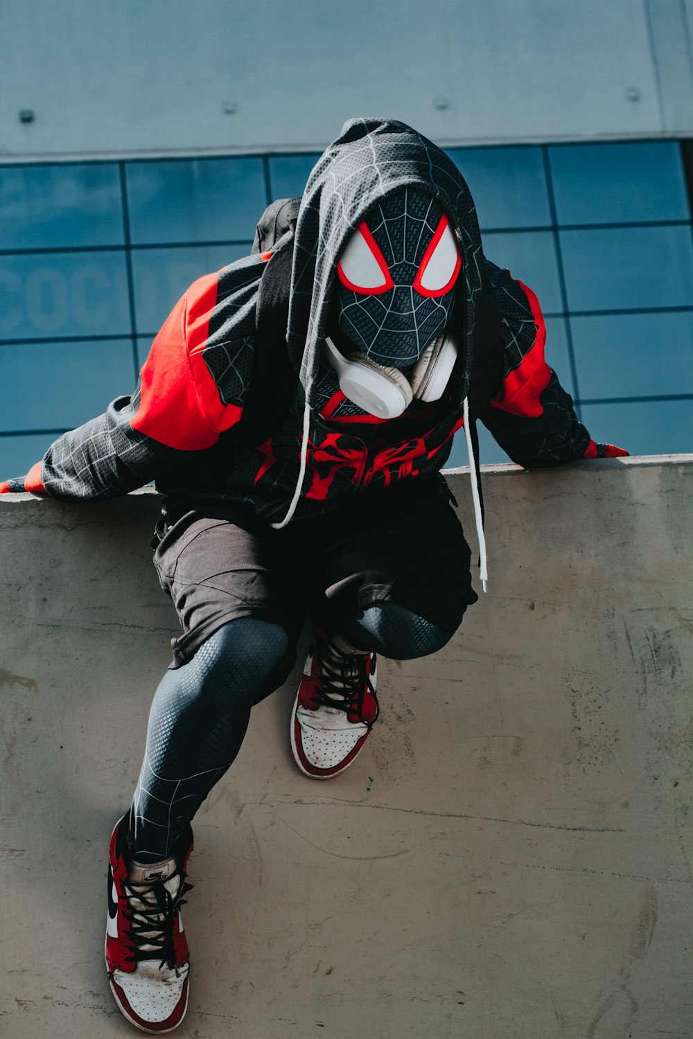 a person wearing a spider man mask on a skateboard