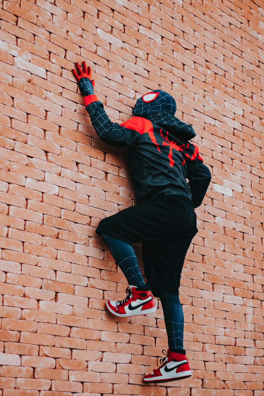 a person climbing up a brick wall