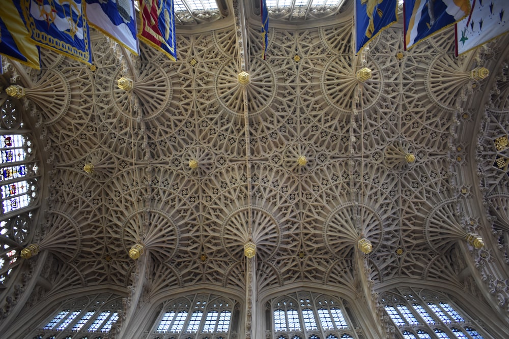 the ceiling of a building with many flags hanging from it