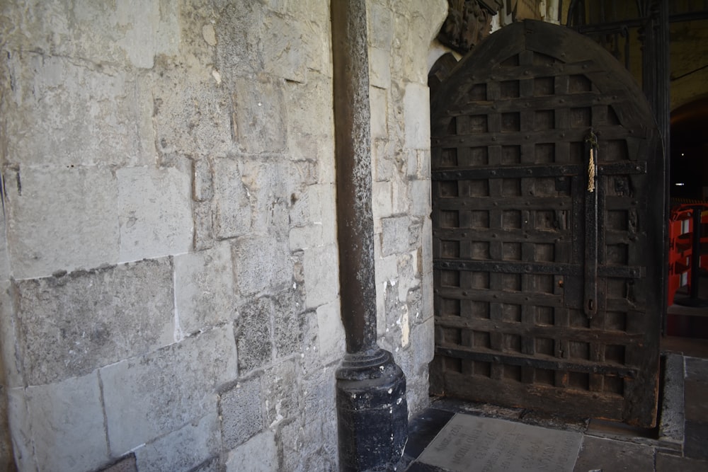 a large wooden door sitting next to a brick wall