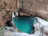 Crystal-clear natural pool nestled within Cotubanamá National Park surrounded by tropical foliage.