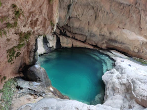 Crystal-clear natural pool nestled within Cotubanamá National Park surrounded by tropical foliage.