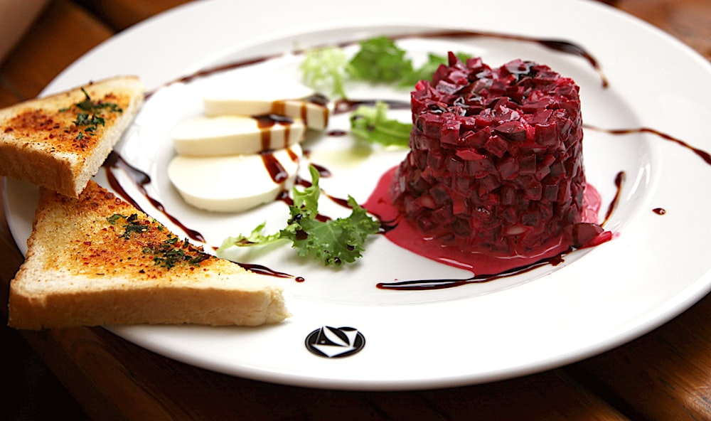 a white plate topped with a piece of bread and a dessert