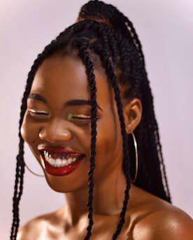 Chic boho knotless bob braids with loose curly ends framing a joyful face.