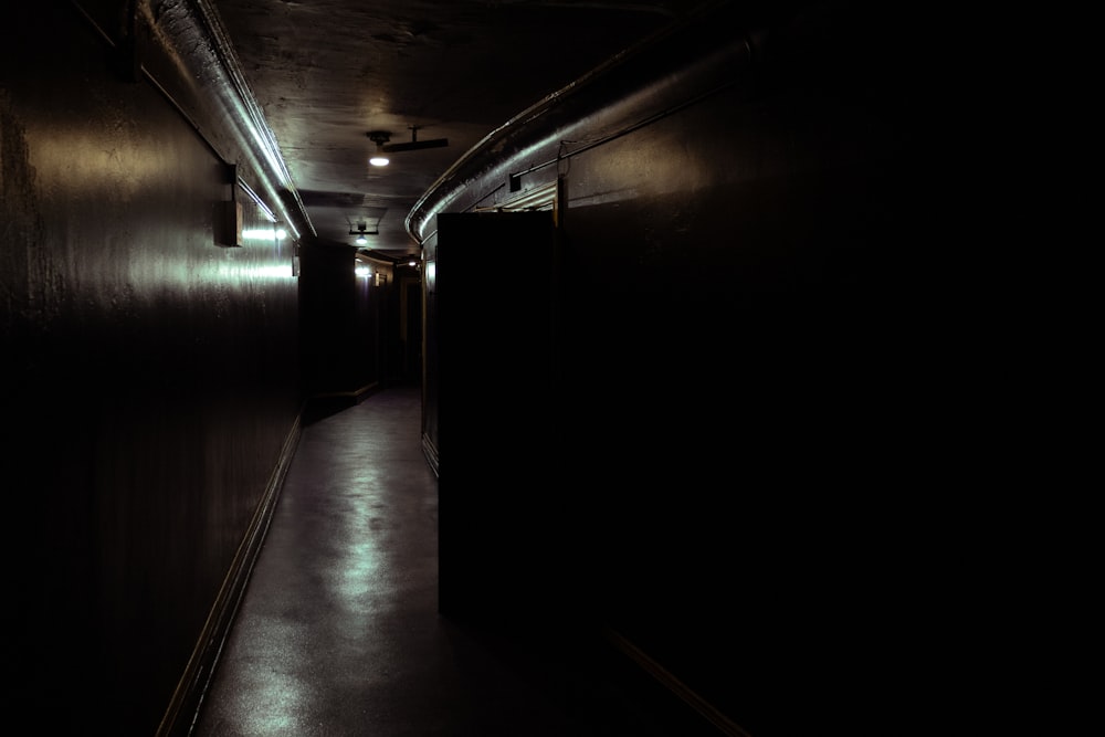 a dark hallway with a light at the end of it