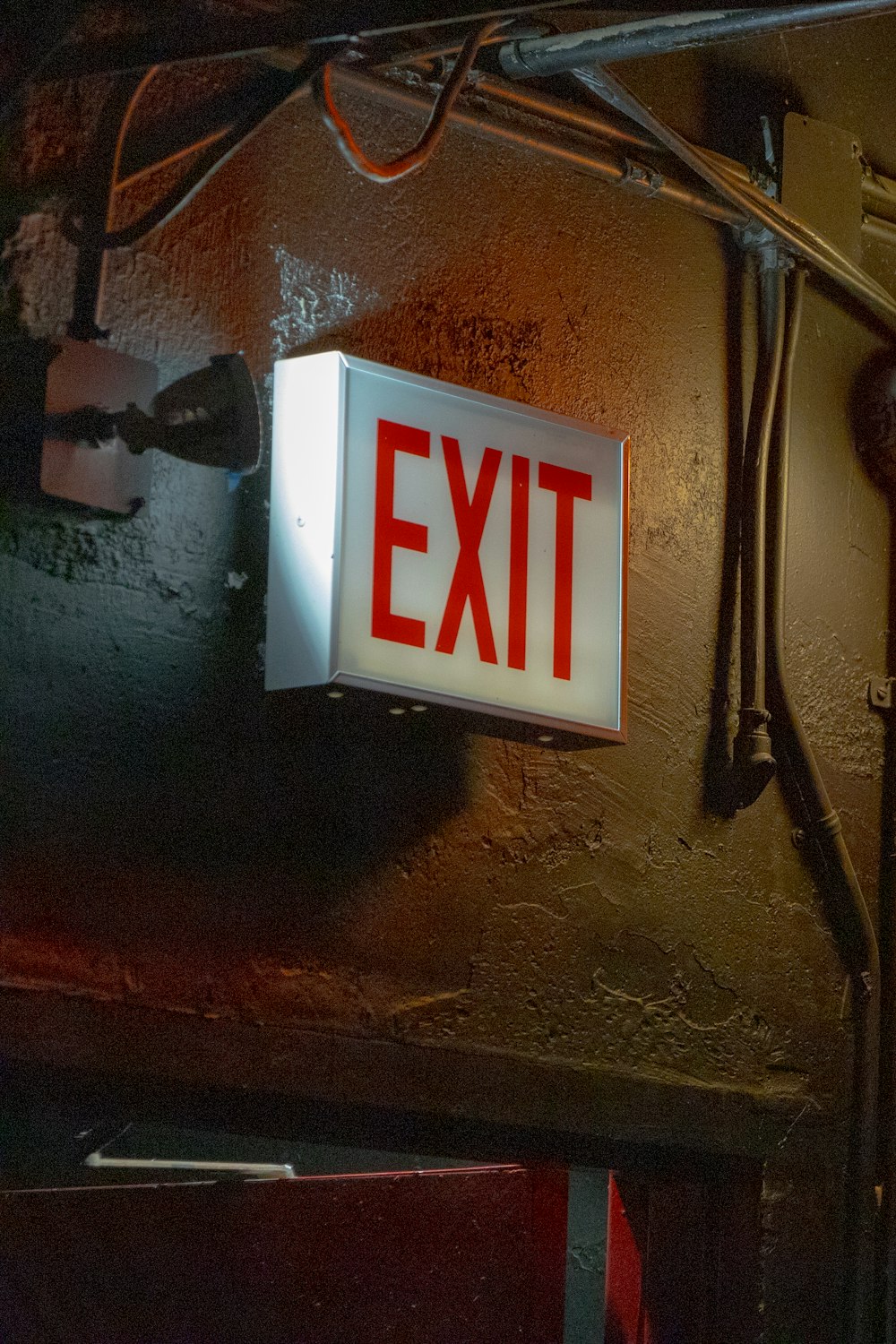 a red exit sign mounted to the side of a wall