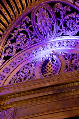 Close-up of skilled hands restoring a decorative ceiling.
