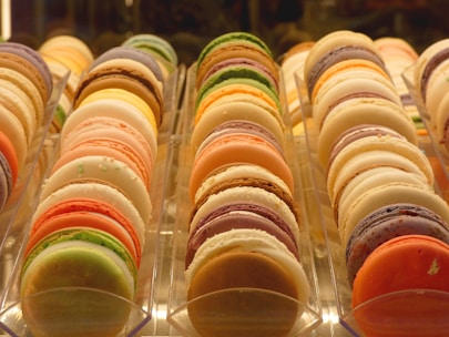 An elegant display of colorful macarons arranged on a marble countertop.