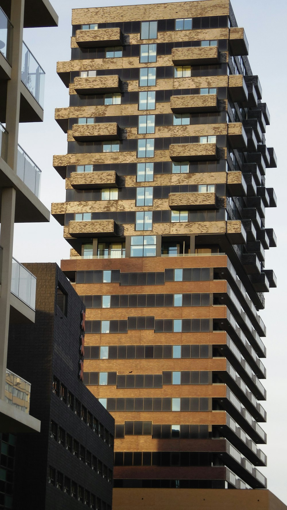 a tall building with lots of windows next to other buildings