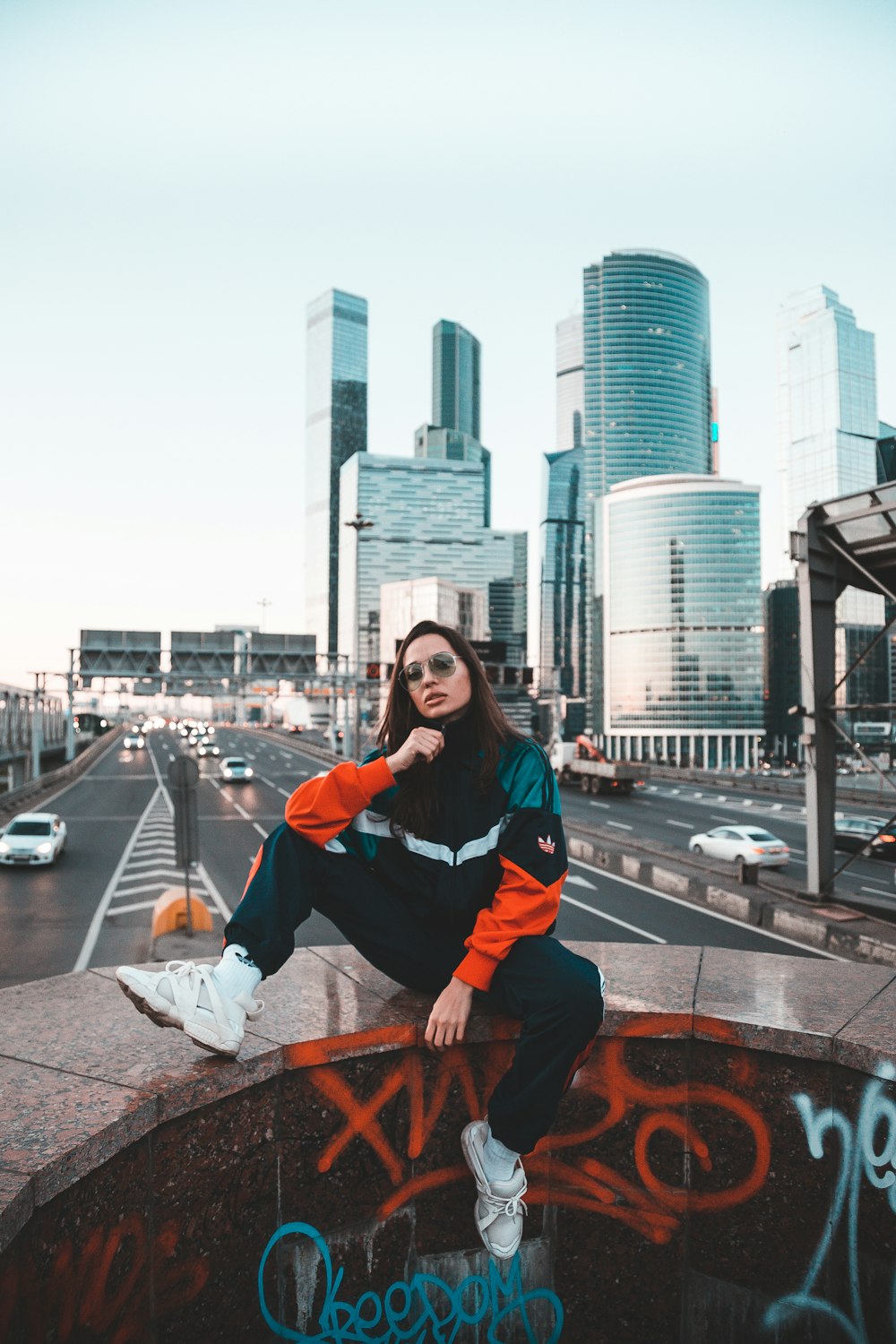 a woman sitting on top of a cement wall