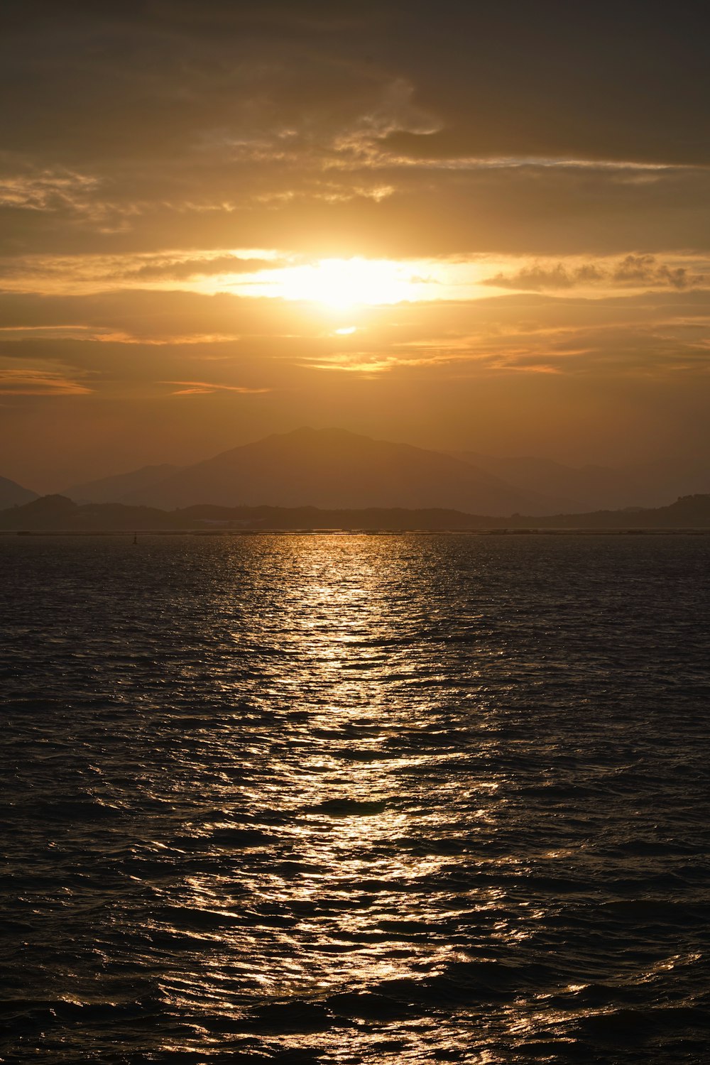 a large body of water with a sunset in the background