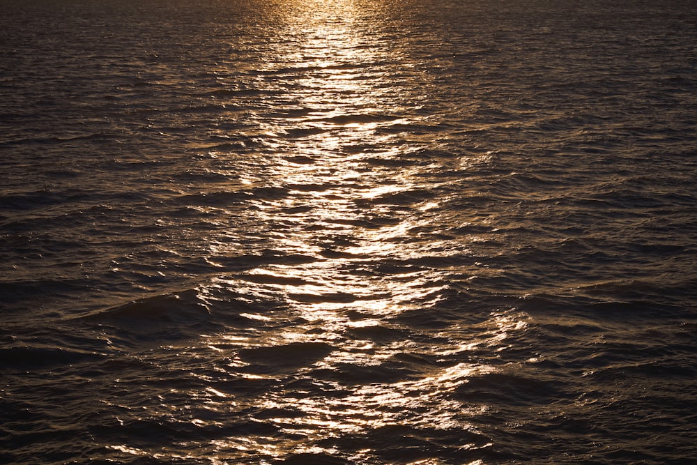 a large body of water with a boat in the distance