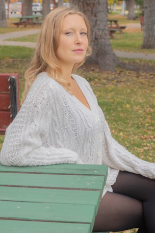 a woman sitting on a bench in a park