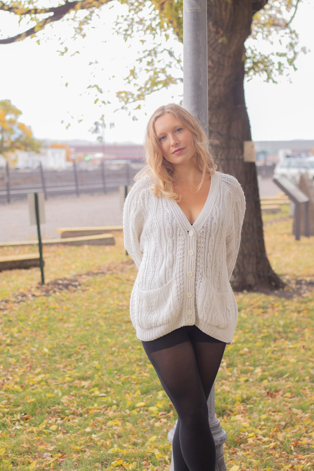a woman in tights and a sweater posing for a picture