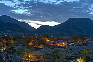 A serene village scene with villagers engaging in community activities under a warm saffron sky.