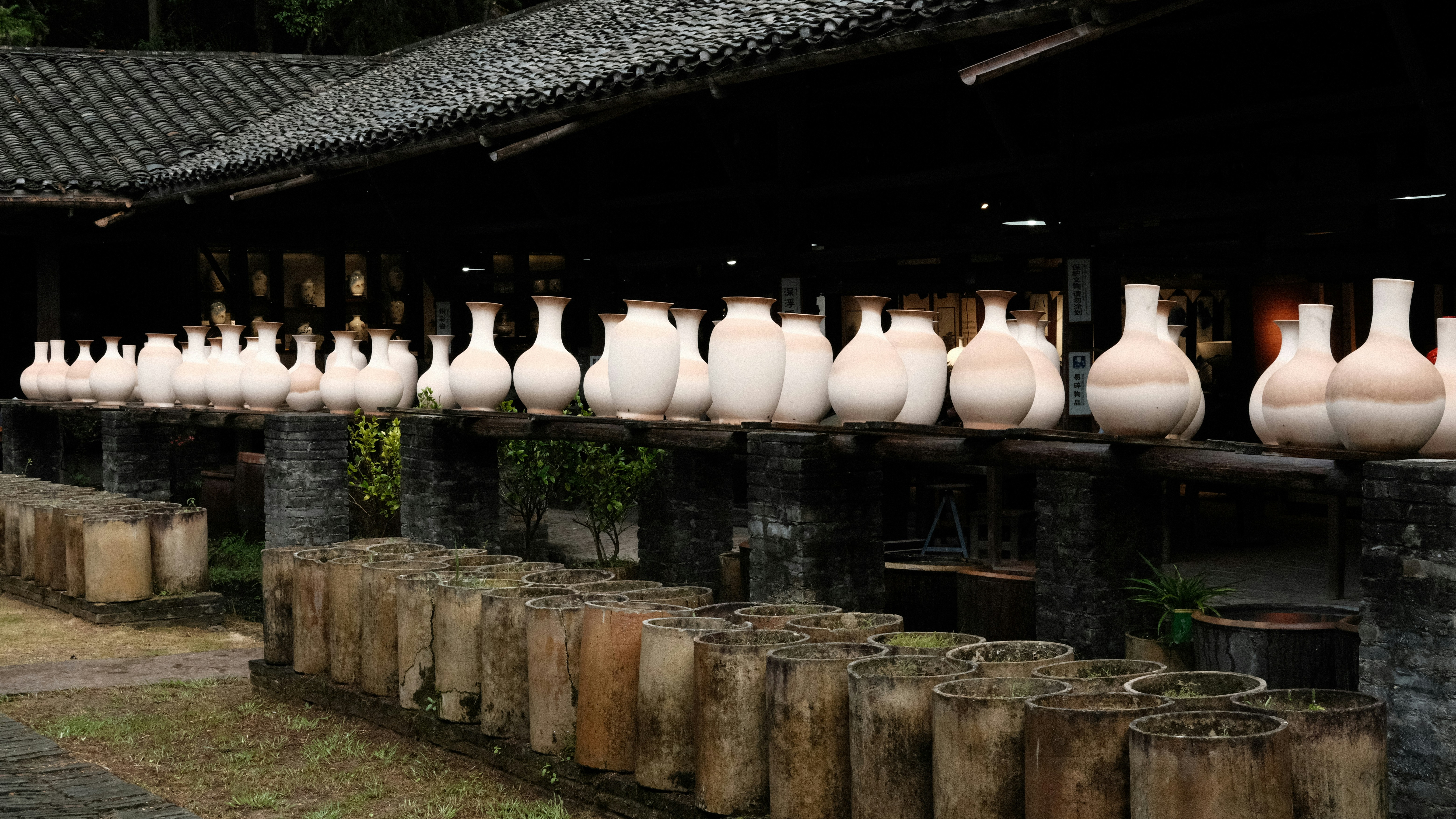 a row of vases sitting on top of a wooden table