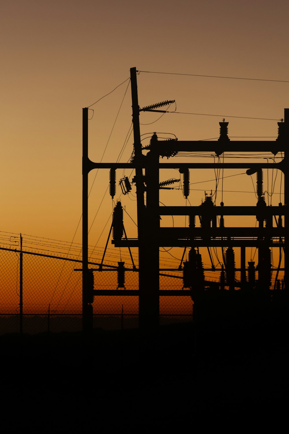 uma silhueta de uma linha de energia com um pôr do sol ao fundo