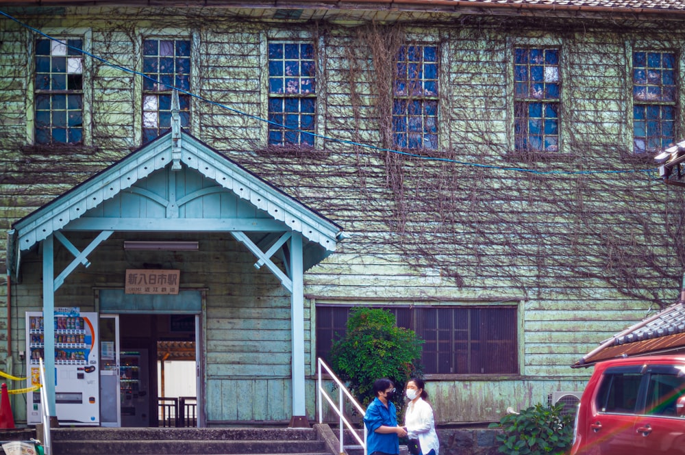 a couple of people that are standing in front of a building