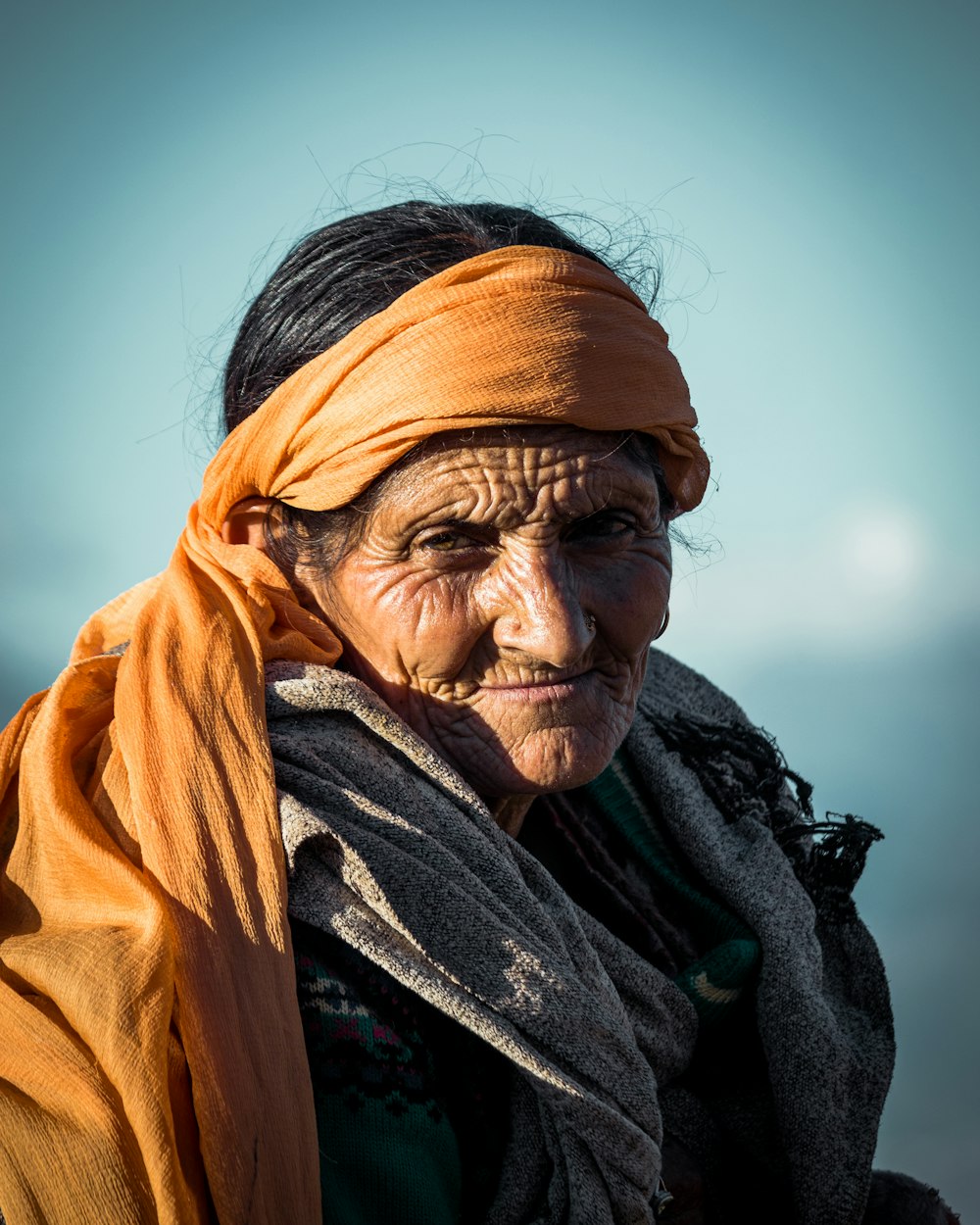 an old woman with a yellow scarf on her head