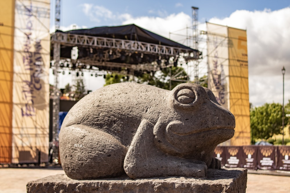 a statue of a frog sitting on top of a stone block