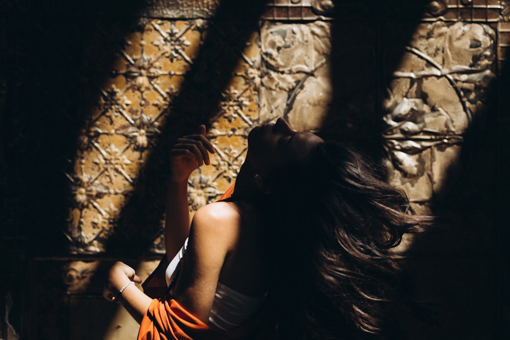 a woman standing in front of a stone wall