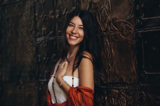 Anastasia smiling warmly against a backdrop of turquoise and gold accents, radiating calm and confidence.