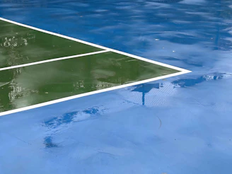 a reflection of a tennis court in water