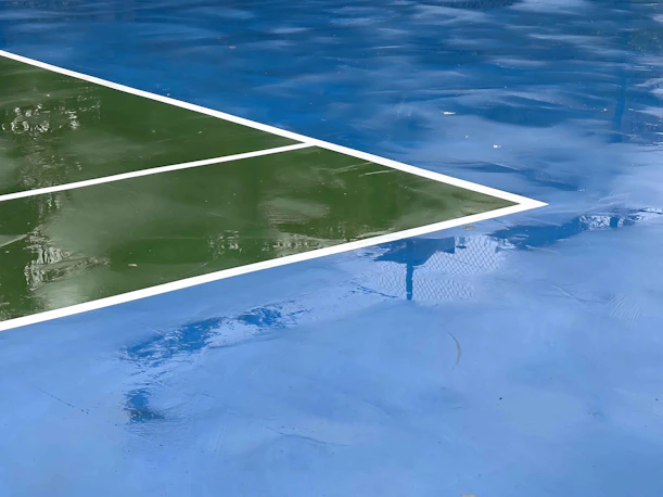 a reflection of a tennis court in water