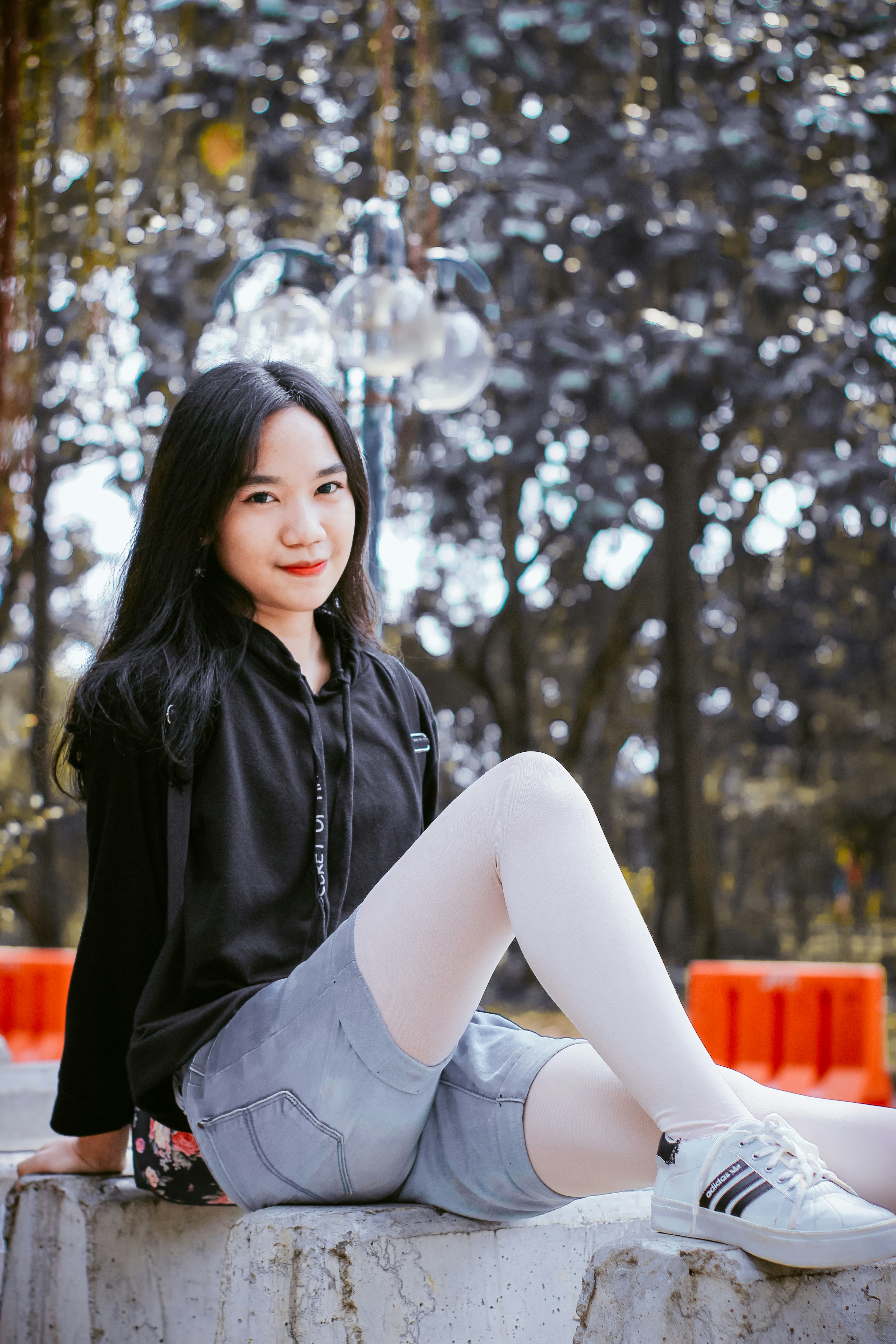 a woman sitting on a rock with her legs crossed
