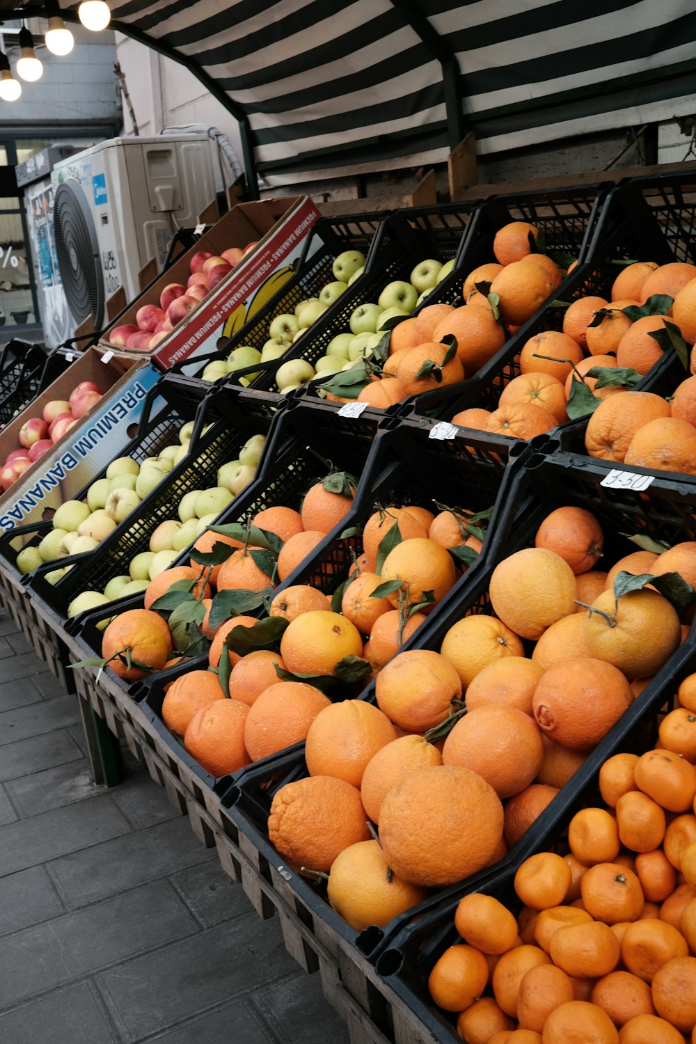 a fruit stand filled with lots of oranges and apples