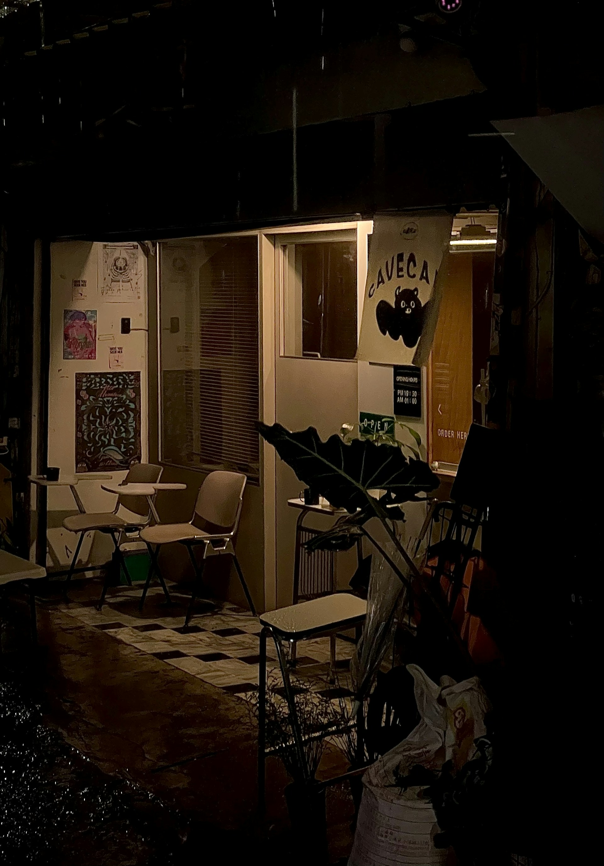 A dimly lit corner of Bhoot Cafe with flickering candles casting eerie shadows on ancient, cobweb-covered walls.