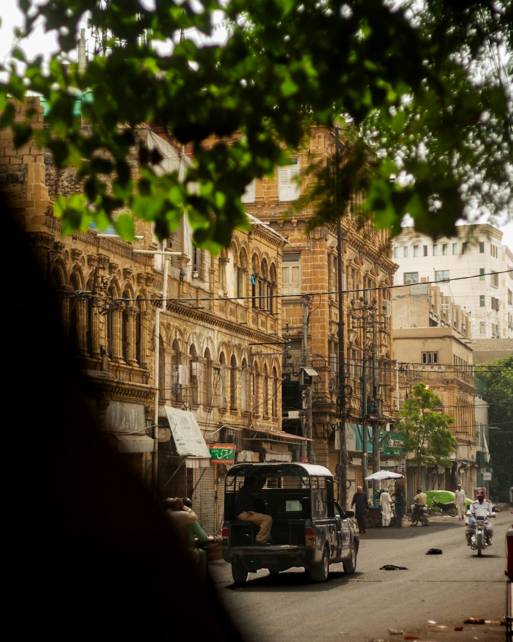 a truck driving down a street next to tall buildings