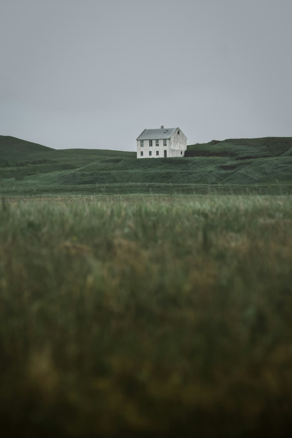 una casa blanca en un campo de hierba verde