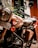 A close-up view of a vintage-style motorcycle with a brown body. The motorcycle features a round headlamp, a prominent fuel tank with decals, and a black leather seat. The license plate is visible with the number 'B5788'. The motorcycle is equipped with leather saddlebags and is positioned indoors against a blurred background.