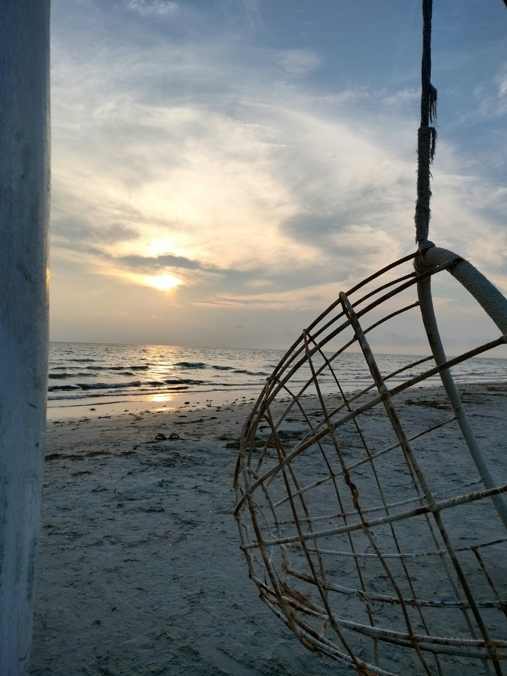 El sol se pone en la playa con un columpio