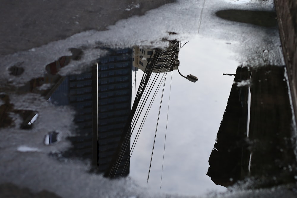 a reflection of a building in a puddle of water