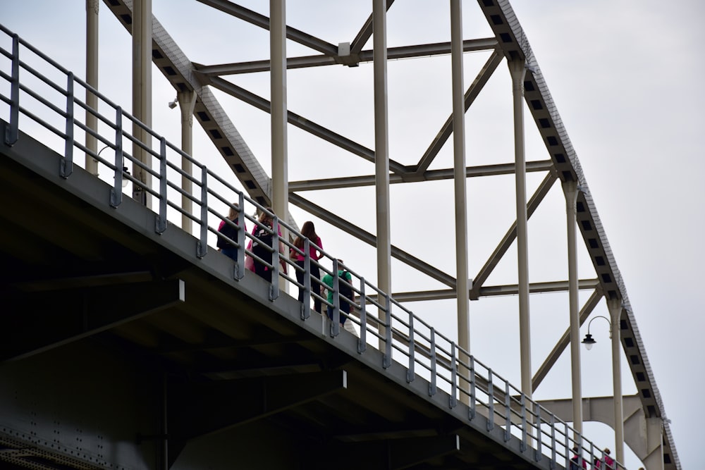 a group of people walking across a bridge