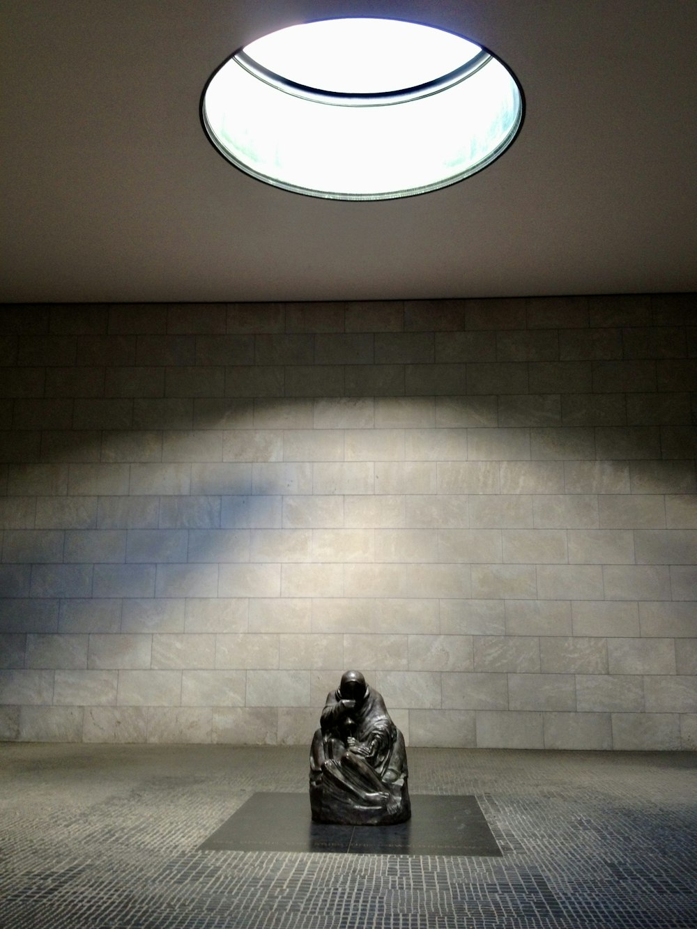 a sculpture in a room with a skylight above it