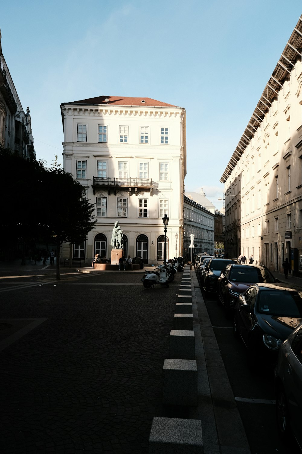 a street lined with parked cars next to tall buildings