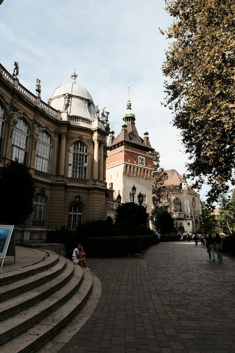 a couple of people sitting on some steps in front of a building