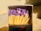 A close-up of a matchbox filled with matches. The matches have wooden sticks and purple heads. The surrounding lighting and shadows create a warm, contrasting effect.