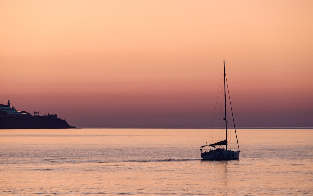 a sailboat in a body of water at sunset