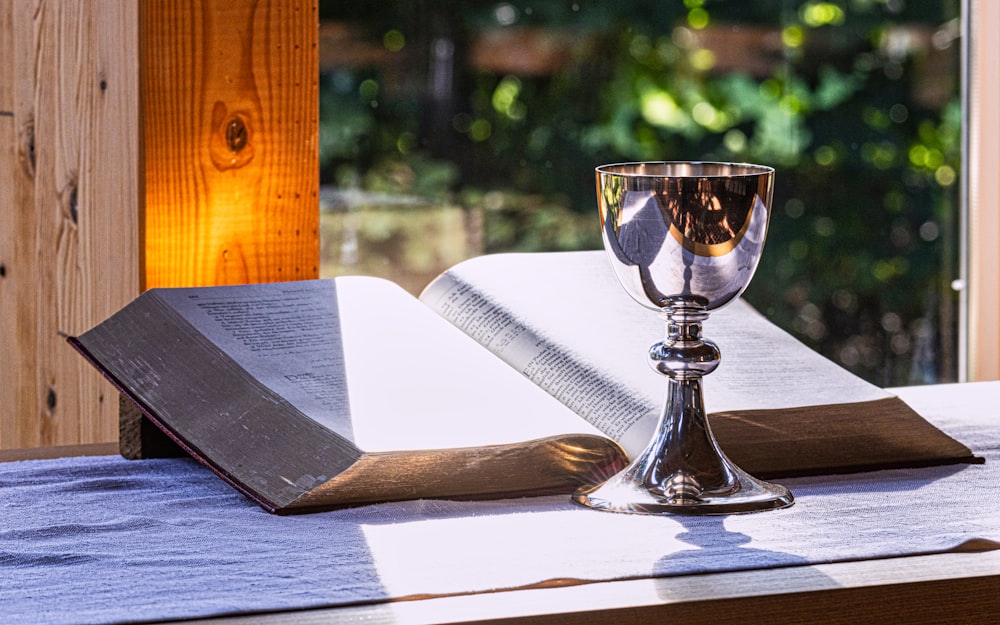 an open book and a chalice on a table