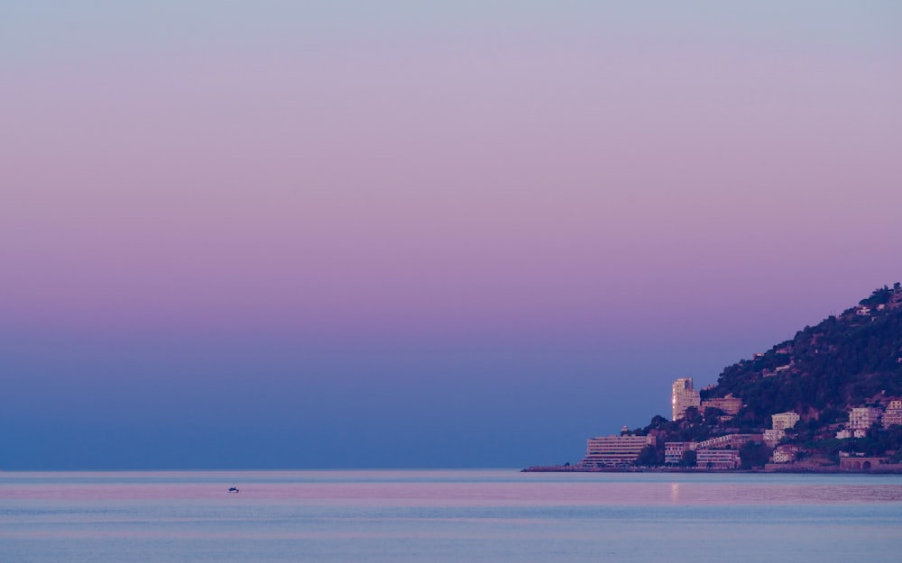 un grande specchio d'acqua con una collina sullo sfondo