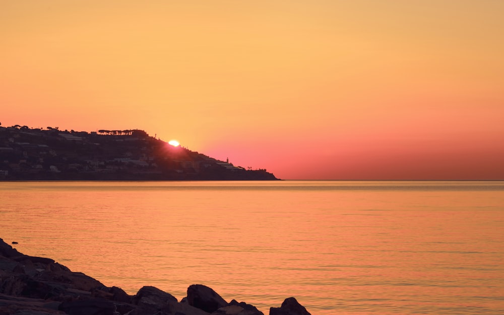 the sun is setting over a body of water