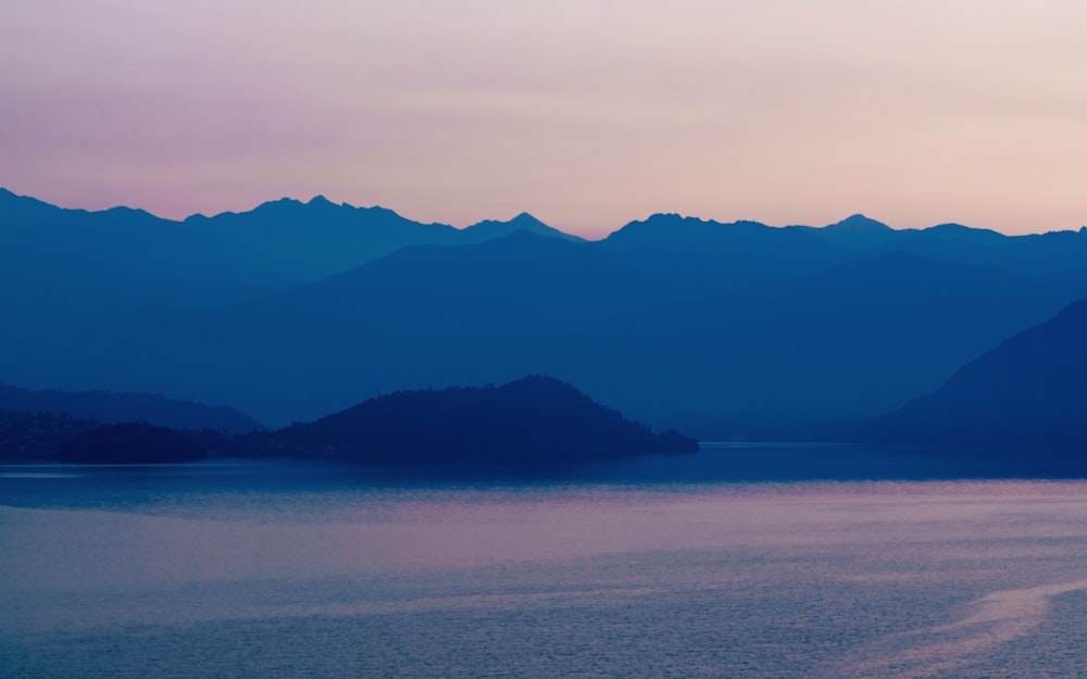 a body of water with mountains in the background